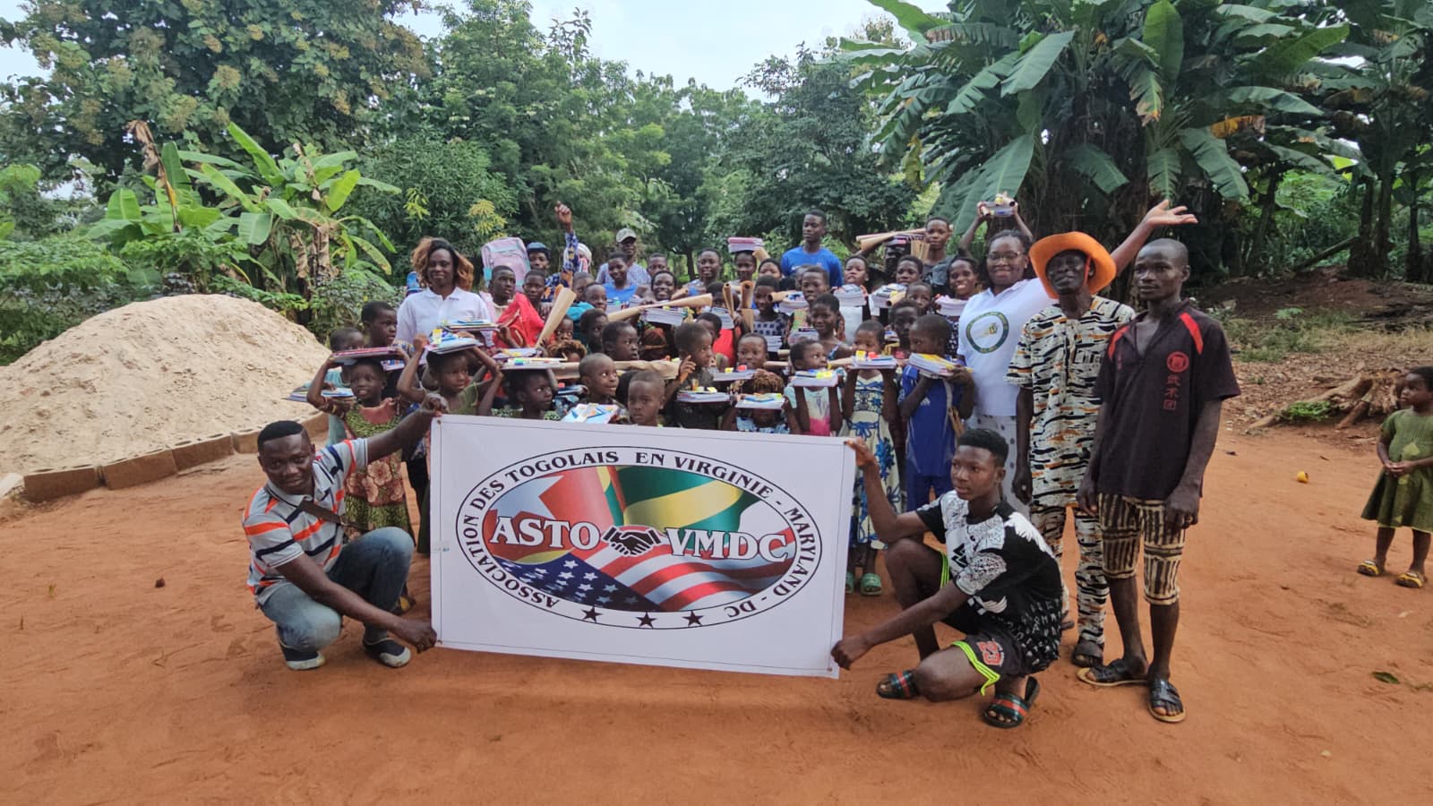 ASTO-VMDC volunteers distributing school supplies to children in Togo