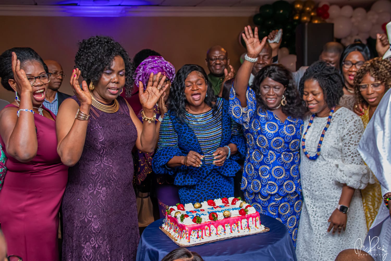 Members celebrating around the cake